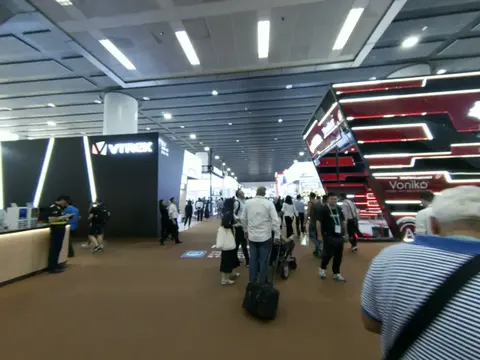 An aisle of electronics booths with visitors